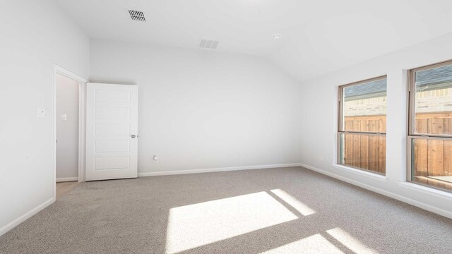 empty room featuring carpet floors and vaulted ceiling