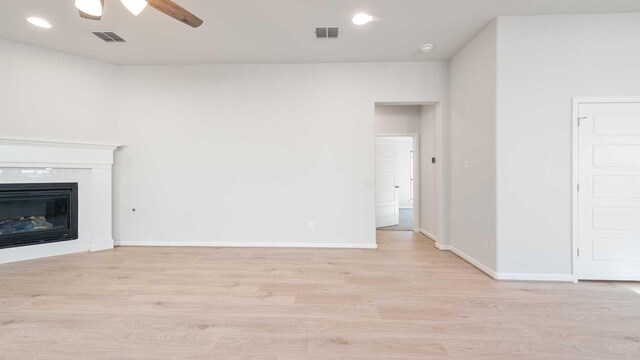 unfurnished living room featuring light hardwood / wood-style flooring and ceiling fan