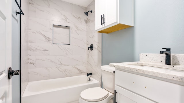 full bathroom featuring vanity, tiled shower / bath, and toilet