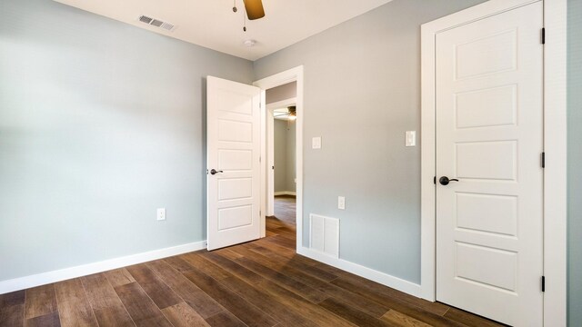 unfurnished bedroom featuring dark wood-type flooring and ceiling fan