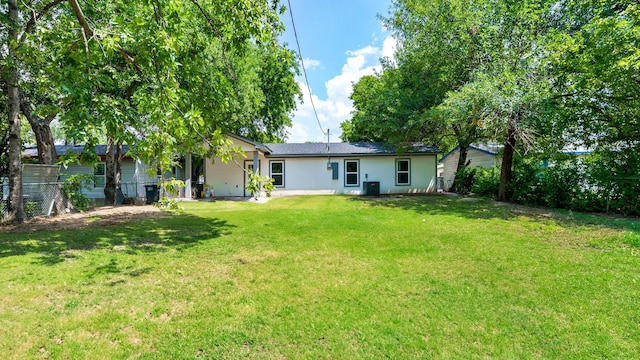 back of house with a yard and central AC