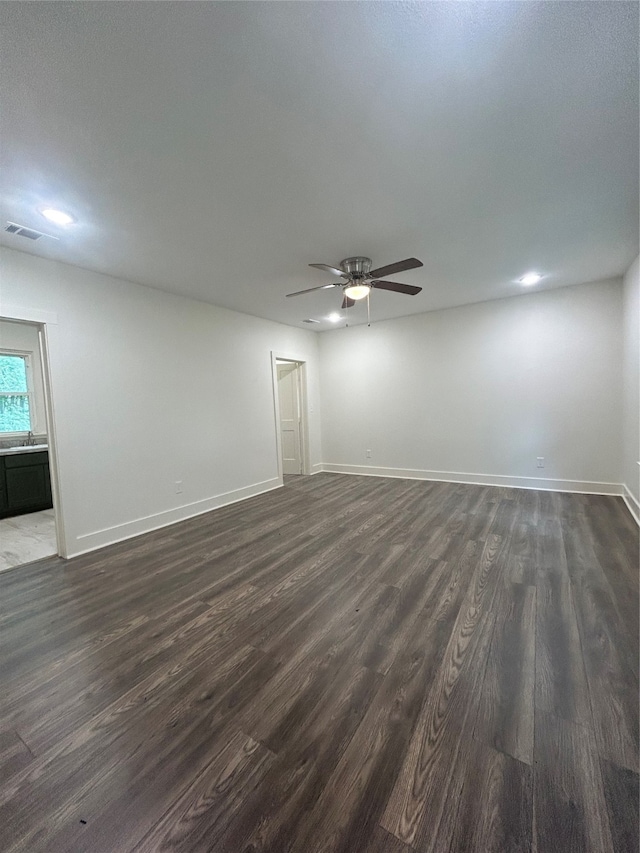 unfurnished room featuring sink, dark wood-type flooring, and ceiling fan