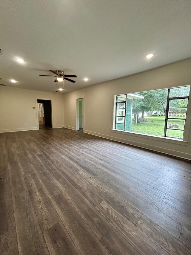 unfurnished living room with dark wood-type flooring and ceiling fan