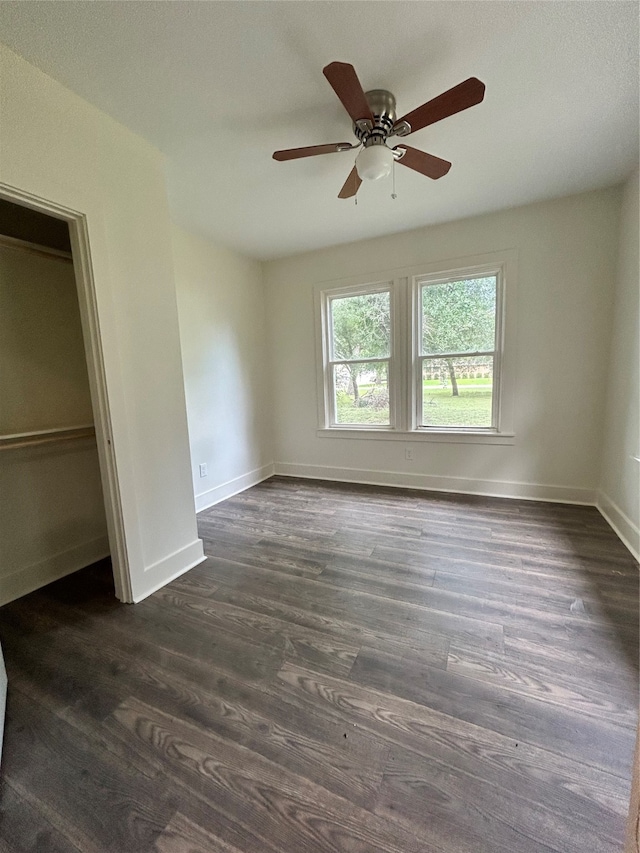 unfurnished bedroom featuring dark hardwood / wood-style flooring, a closet, and ceiling fan