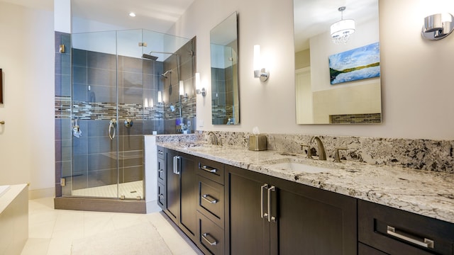 bathroom with tile patterned floors, a shower with door, and dual bowl vanity