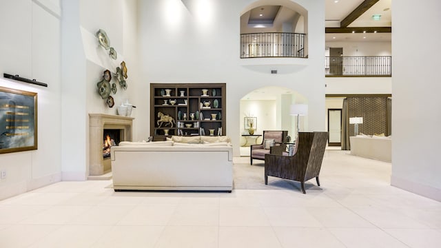 tiled living room with beamed ceiling and a towering ceiling