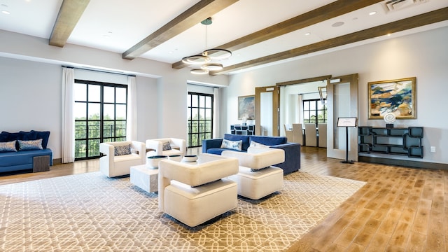 living room with beamed ceiling, light hardwood / wood-style floors, and a notable chandelier