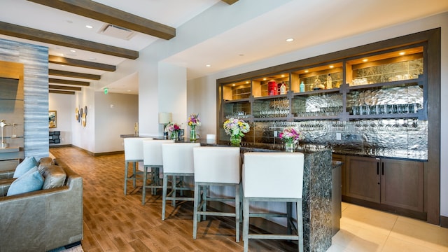 bar featuring light hardwood / wood-style flooring and beam ceiling