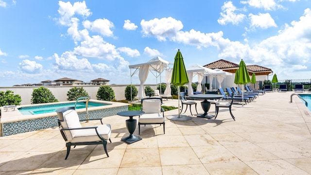 view of patio / terrace with a pool with hot tub