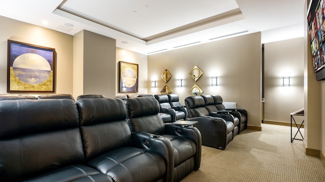 home theater featuring light colored carpet and a tray ceiling