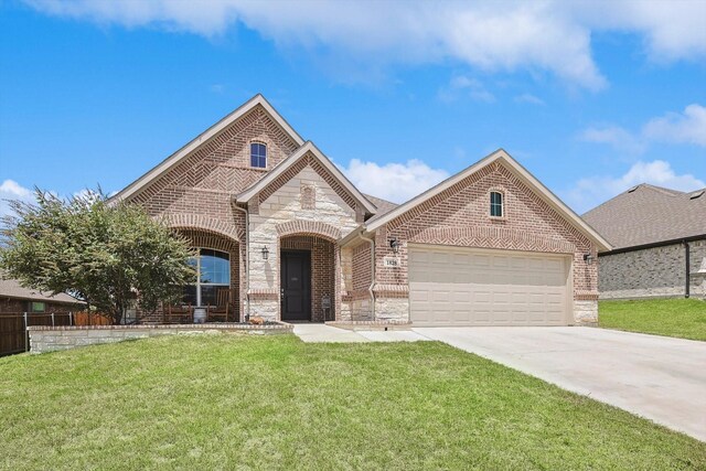 view of front of property featuring a garage and a front lawn