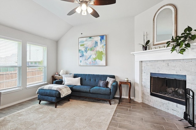 living room with a fireplace, ceiling fan, and vaulted ceiling