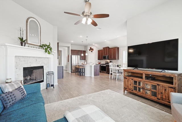 living room with a brick fireplace, light tile patterned floors, and ceiling fan