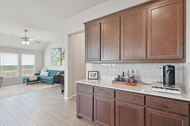 kitchen with lofted ceiling, ceiling fan, and backsplash