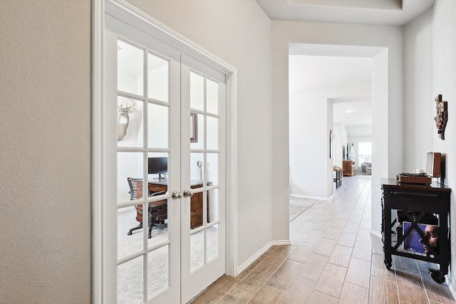 corridor with french doors and light hardwood / wood-style floors