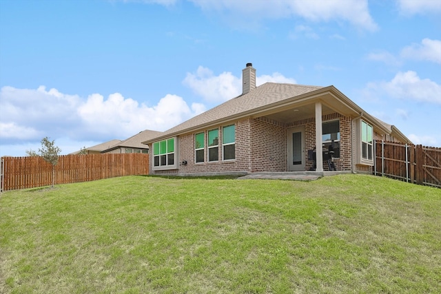 rear view of property with a yard and a patio area