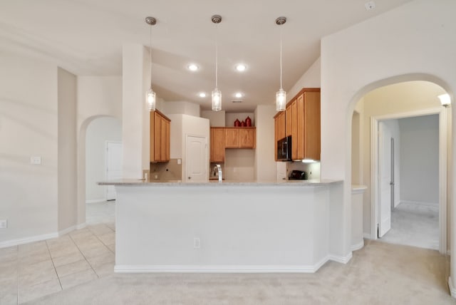 kitchen featuring light stone countertops, sink, kitchen peninsula, hanging light fixtures, and light colored carpet