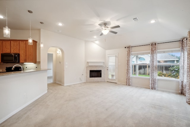 unfurnished living room featuring lofted ceiling, light colored carpet, and ceiling fan