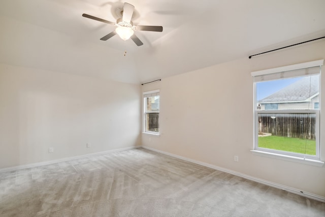 spare room featuring plenty of natural light, light carpet, and ceiling fan