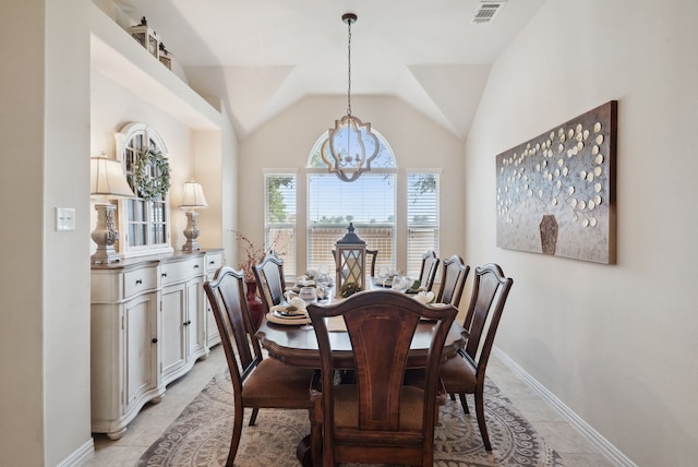 dining space with lofted ceiling, a chandelier, and light tile patterned floors