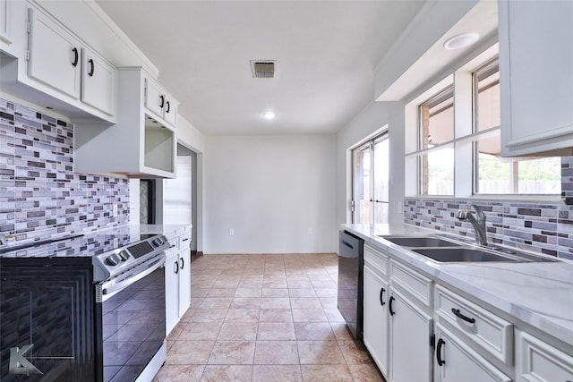 kitchen with decorative backsplash, light tile patterned floors, stainless steel range with electric cooktop, and sink