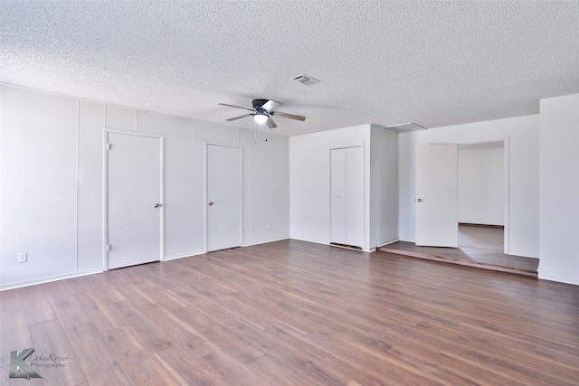 spare room with ceiling fan, a textured ceiling, and hardwood / wood-style flooring