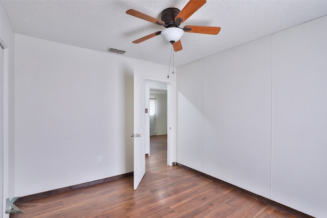 spare room featuring hardwood / wood-style flooring, a textured ceiling, and ceiling fan