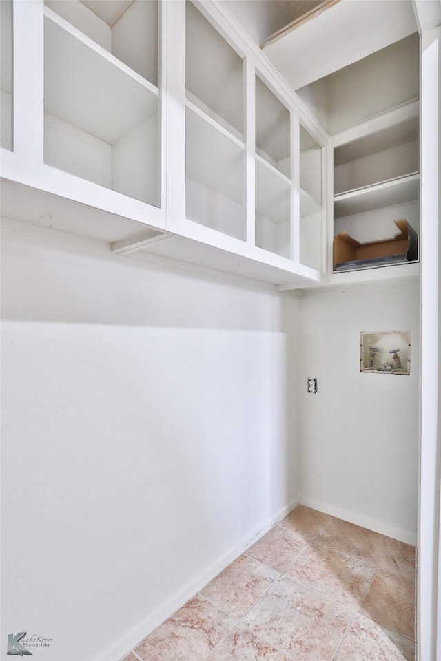 interior space featuring hookup for a washing machine and light tile patterned floors