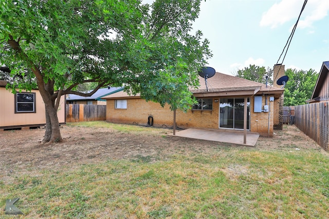 back of property with a patio and a yard