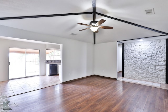 unfurnished living room featuring tile patterned floors, ceiling fan, and vaulted ceiling with beams