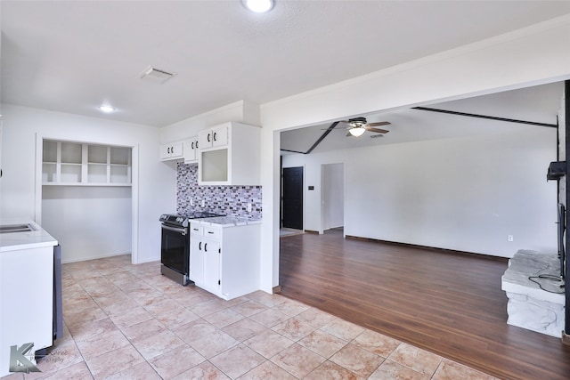 kitchen with light tile patterned flooring, ceiling fan, white cabinets, stainless steel range with electric cooktop, and backsplash