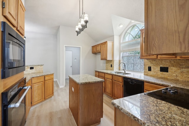 kitchen featuring light hardwood / wood-style flooring, a kitchen island, black appliances, decorative backsplash, and sink