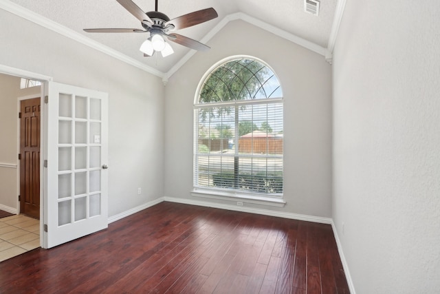 empty room with wood-type flooring, crown molding, vaulted ceiling, and ceiling fan