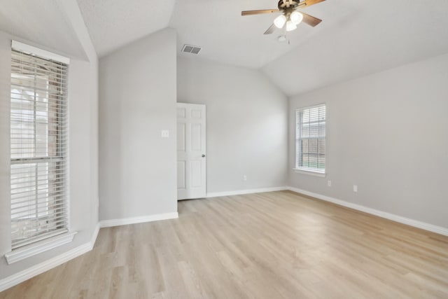 spare room featuring vaulted ceiling, ceiling fan, and light wood-type flooring