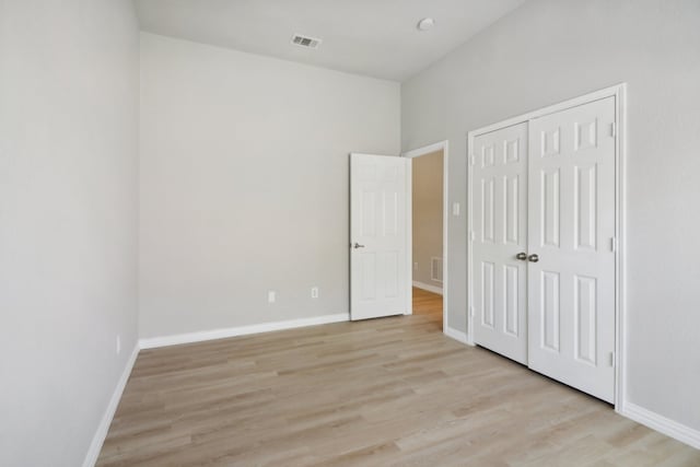 unfurnished bedroom with light hardwood / wood-style floors and a closet