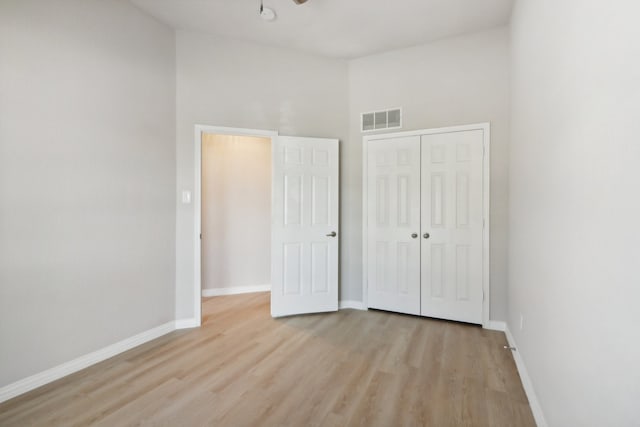 unfurnished bedroom with light hardwood / wood-style flooring and a closet