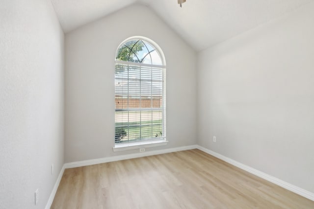 unfurnished room with vaulted ceiling and light wood-type flooring