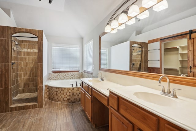 bathroom featuring tile patterned floors, separate shower and tub, lofted ceiling, and dual bowl vanity