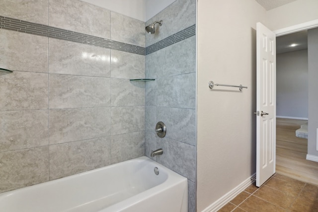 bathroom with hardwood / wood-style flooring and tiled shower / bath