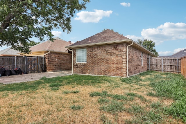 back of property with a patio area and a lawn