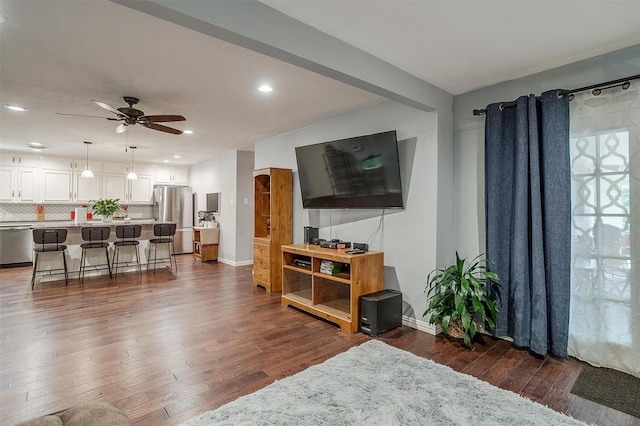 living room featuring ceiling fan and dark hardwood / wood-style floors