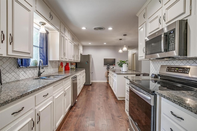 kitchen with sink, decorative light fixtures, dark hardwood / wood-style floors, stainless steel appliances, and white cabinets