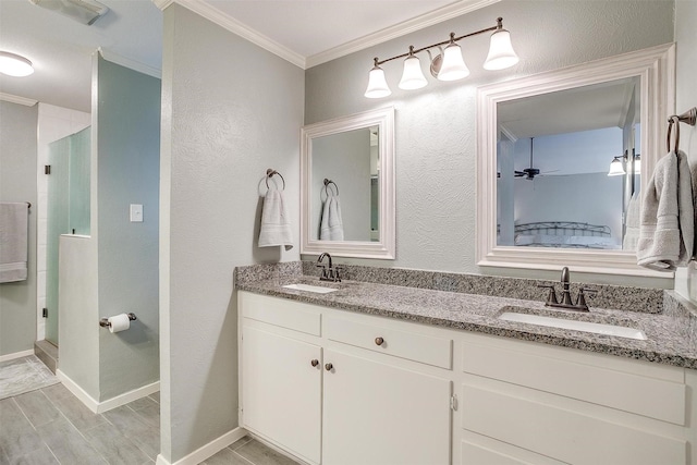 bathroom featuring crown molding, ceiling fan, vanity, and a shower with shower door