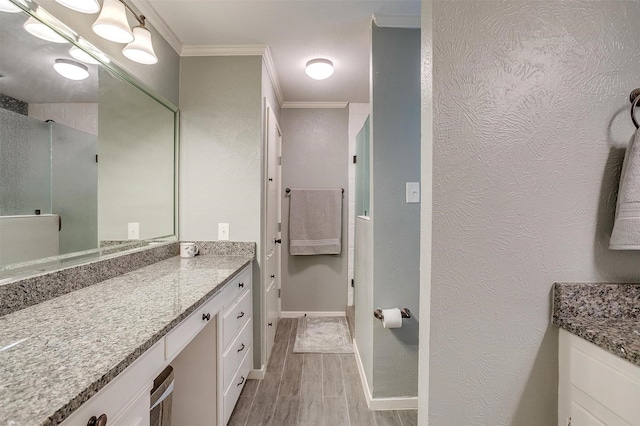 bathroom featuring vanity, wood-type flooring, ornamental molding, and walk in shower