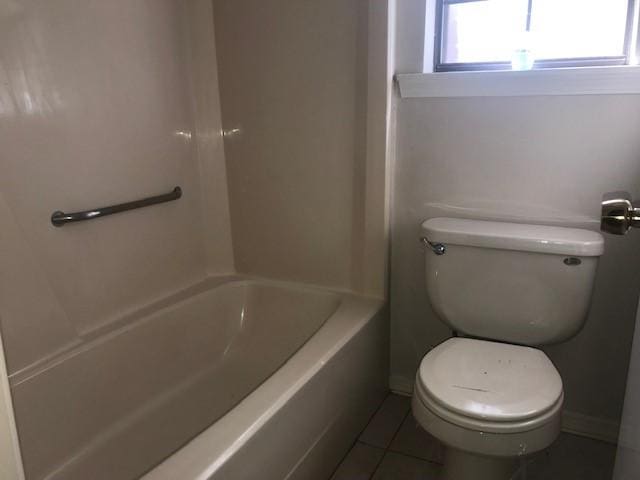 bathroom with tile patterned floors, toilet, and bathing tub / shower combination