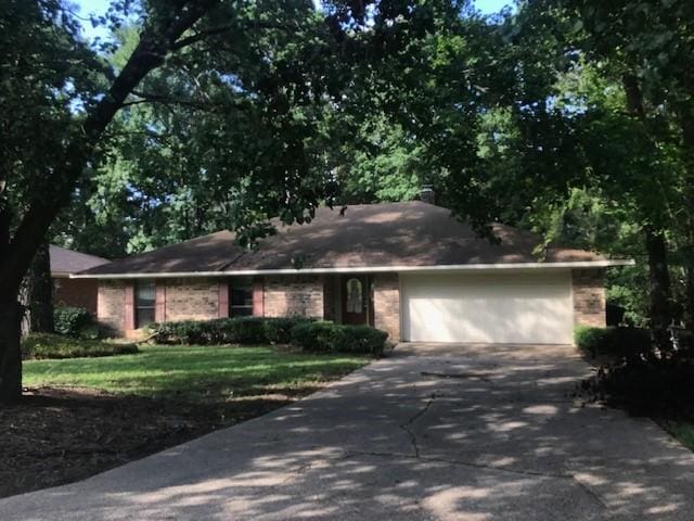 single story home with a garage and a front yard