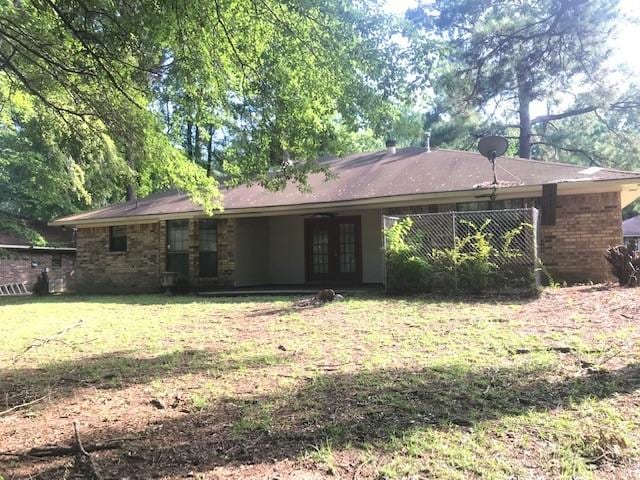 back of property with a yard and french doors