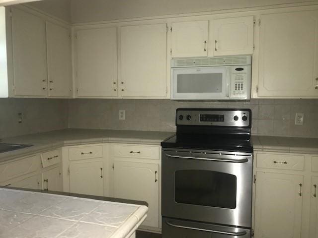 kitchen featuring white cabinetry and electric range