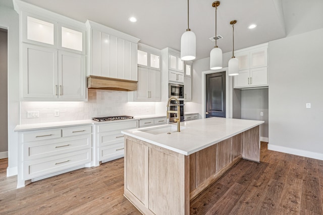 kitchen with white cabinetry, light wood-type flooring, and tasteful backsplash