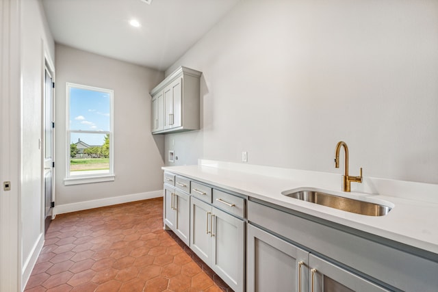 clothes washing area featuring cabinets, sink, and light tile patterned flooring